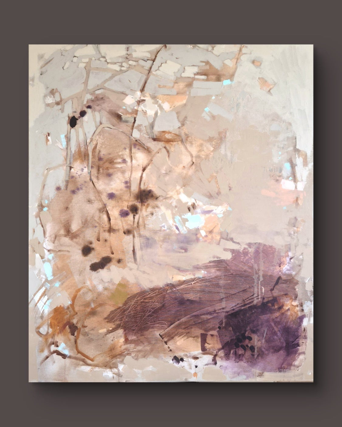 An abstract canvas painting featuring textured brushstrokes in beige, brown, gold, and deep purple, displayed against a solid dark gray background.