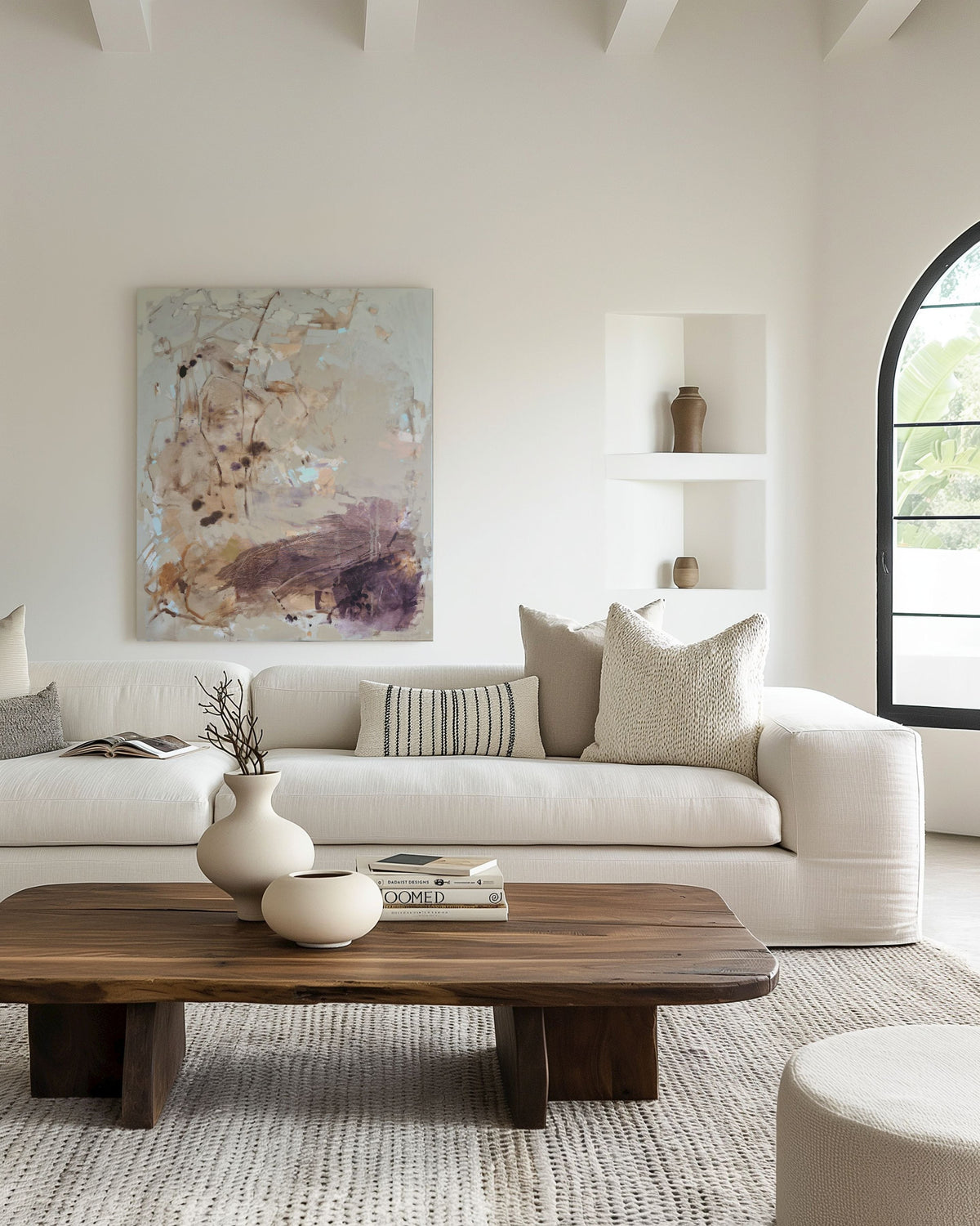Modern living room with a white sofa, wooden coffee table, and floral artwork on the wall.