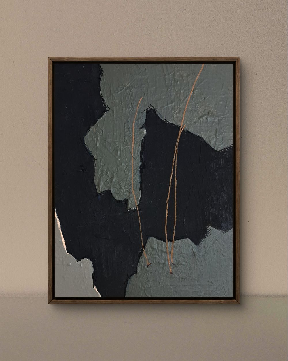 Abstract art piece with textured black and gray design on a beige wall.