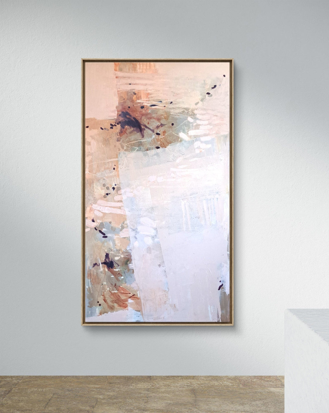 Abstract painting in a wooden frame on a white wall