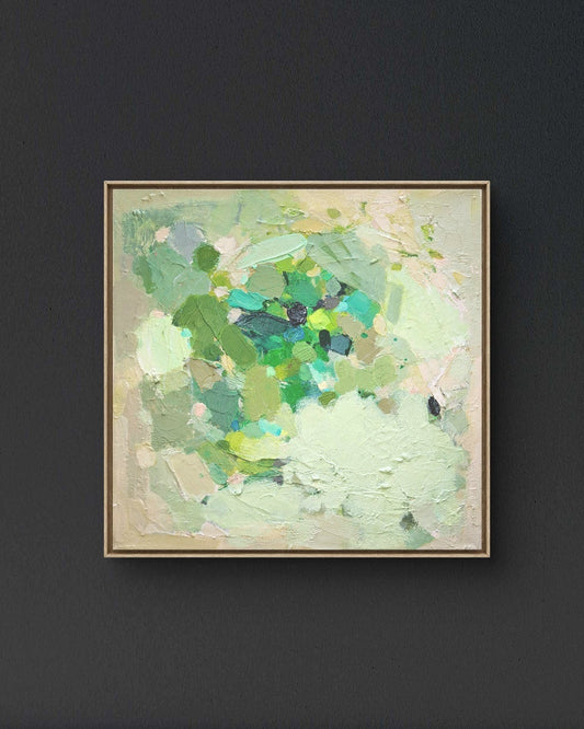 Abstract art piece with green and beige colors on a dark wall.