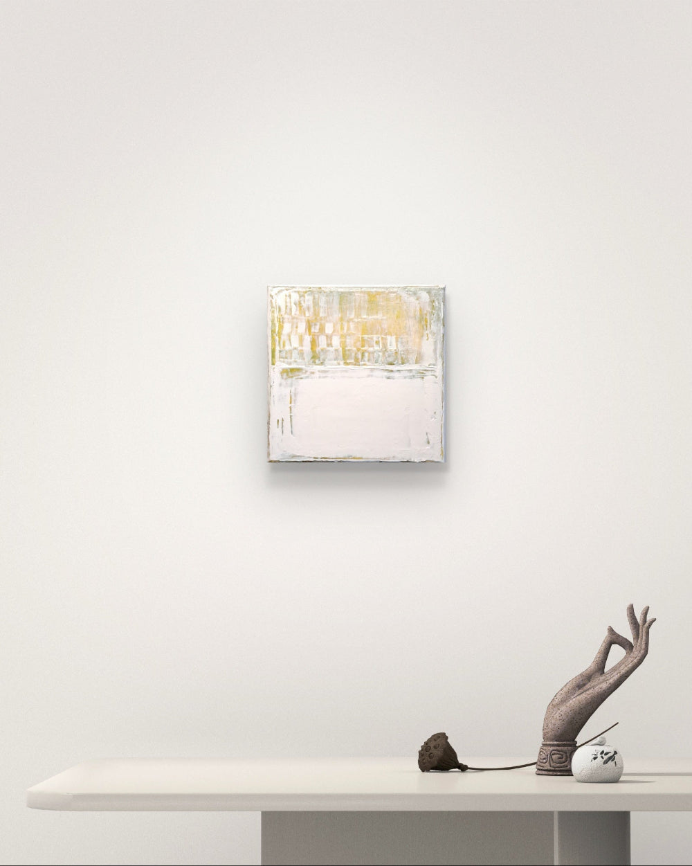 Abstract painting on a white wall above a table with decorative items.