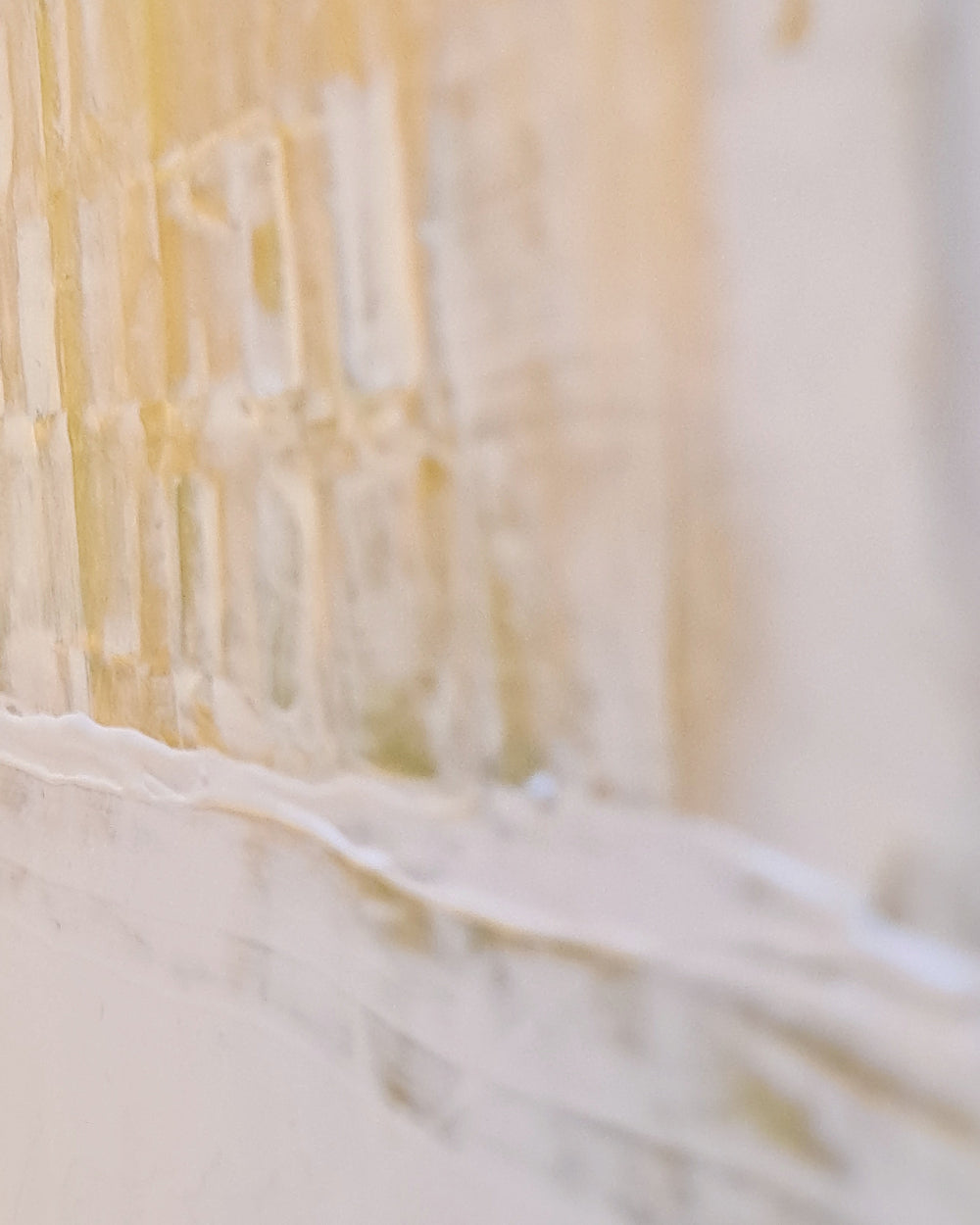 Close-up of a textured surface with light yellow and white colors.